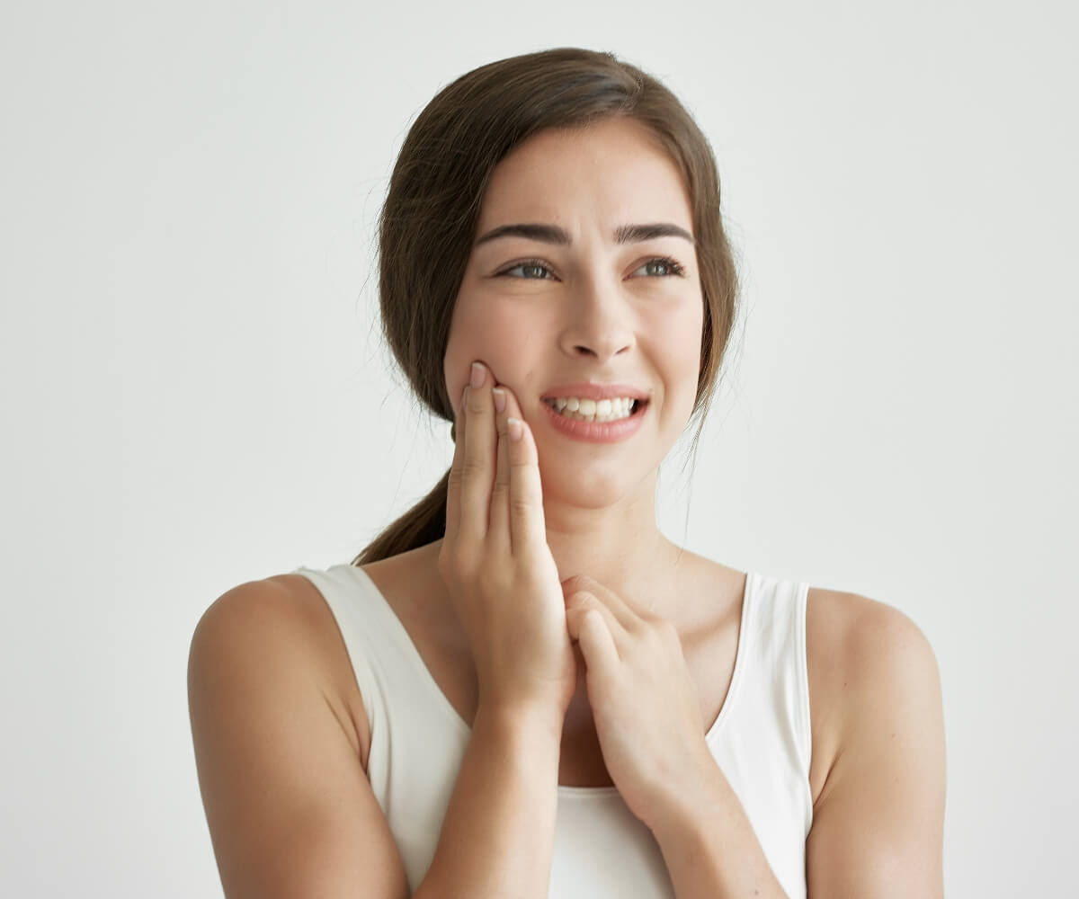 Mujer con dolor mandibular Trastornos Temporomandibulares